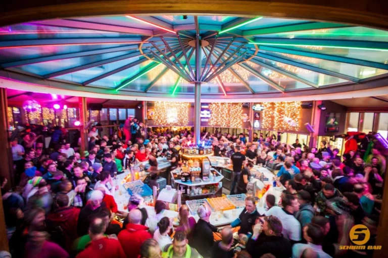 Guests dancing and enjoying après-ski festivities at Schirmbar Sonne in Sölden, Austria, featuring lively music and a vibrant alpine party atmosphere Guests dancing and enjoying après-ski festivities at Schirmbar Sonne in Sölden, Austria, featuring lively music and a vibrant alpine party atmosphere