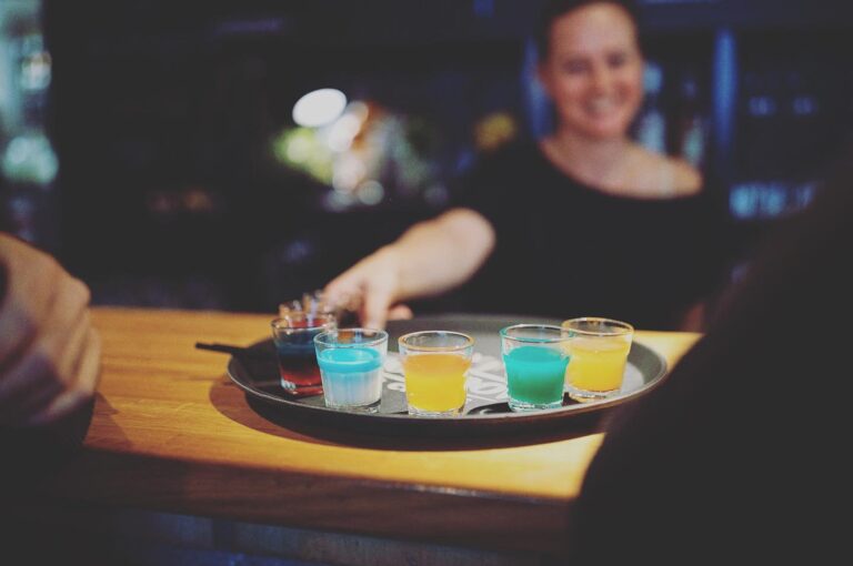 Female bartender serving shots at Haltestelle Shotbar in Innsbruck, Austria, engaging with patrons in a lively and vibrant après-ski atmosphere Female bartender serving shots at Haltestelle Shotbar in Innsbruck, Austria, engaging with patrons in a lively and vibrant après-ski atmosphere