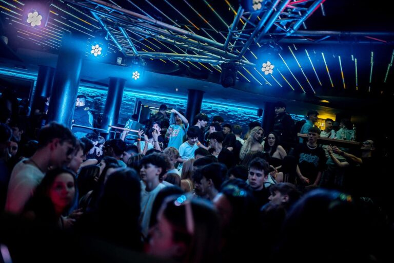 Energetic crowd dancing on the illuminated dance floor at Blue Chip Club in Innsbruck, Austria, showcasing a vibrant nightlife atmosphere with dynamic lighting and a diverse mix of partygoers enjoying various music genres Energetic crowd dancing on the illuminated dance floor at Blue Chip Club in Innsbruck, Austria, showcasing a vibrant nightlife atmosphere with dynamic lighting and a diverse mix of partygoers enjoying various music genres