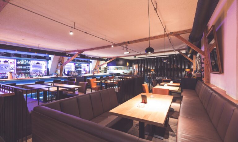 Interior of Die Wäscherei in Innsbruck, Austria, showcasing a modern and cozy atmosphere with a spacious bar area, billiard tables, and lounge seating, offering a vibrant social space for dining, drinks, and entertainment Interior of Die Wäscherei in Innsbruck, Austria, showcasing a modern and cozy atmosphere with a spacious bar area, billiard tables, and lounge seating, offering a vibrant social space for dining, drinks, and entertainment