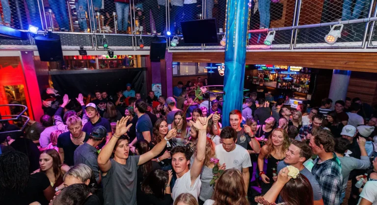 Partygoers dancing energetically on the vibrant dance floor at Fire & Ice nightclub in Sölden, Austria, surrounded by colorful lights and a high-energy après-ski atmosphere Partygoers dancing energetically on the vibrant dance floor at Fire & Ice nightclub in Sölden, Austria, surrounded by colorful lights and a high-energy après-ski atmosphere